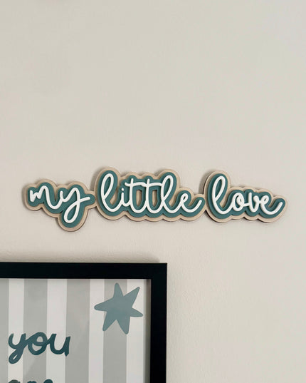 Decorative wall art with 'my little love' text on a plain wall.