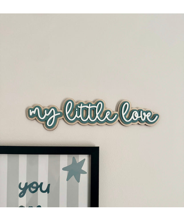 Decorative wall art with 'my little love' text on a plain wall.